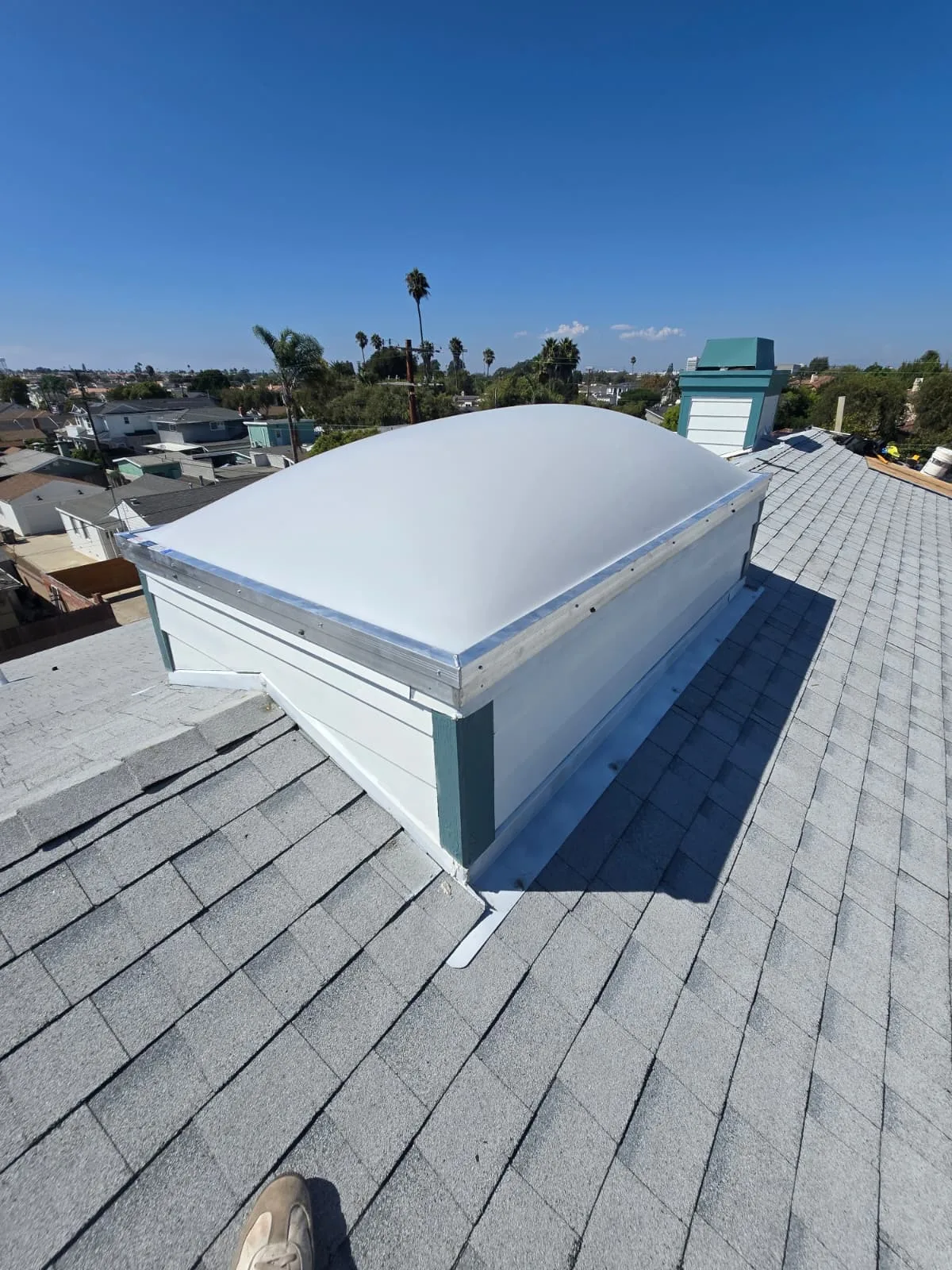Tinted flat glass skylight with dark anodized frame on a flat rooftop in Beverly Hills