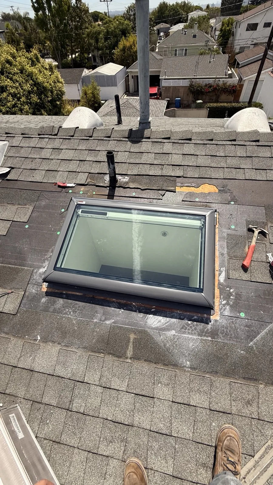 Deck-mounted flat glass skylight installed on a Spanish tile roof in Hollywood