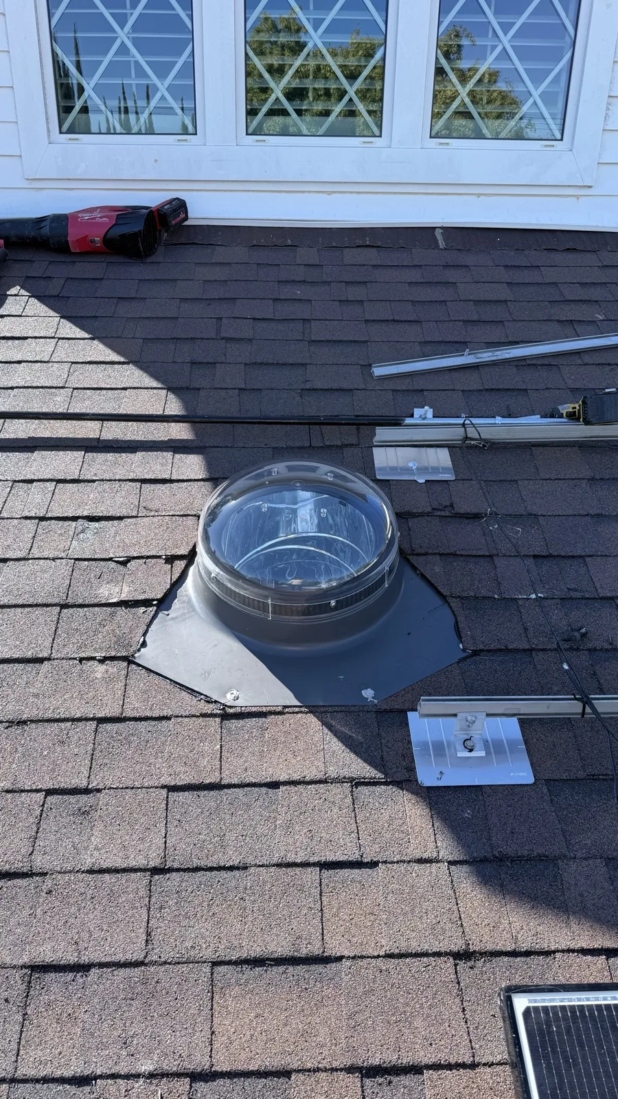 Velux Sun Tunnel dome installation on an asphalt shingle roof in Los Angeles